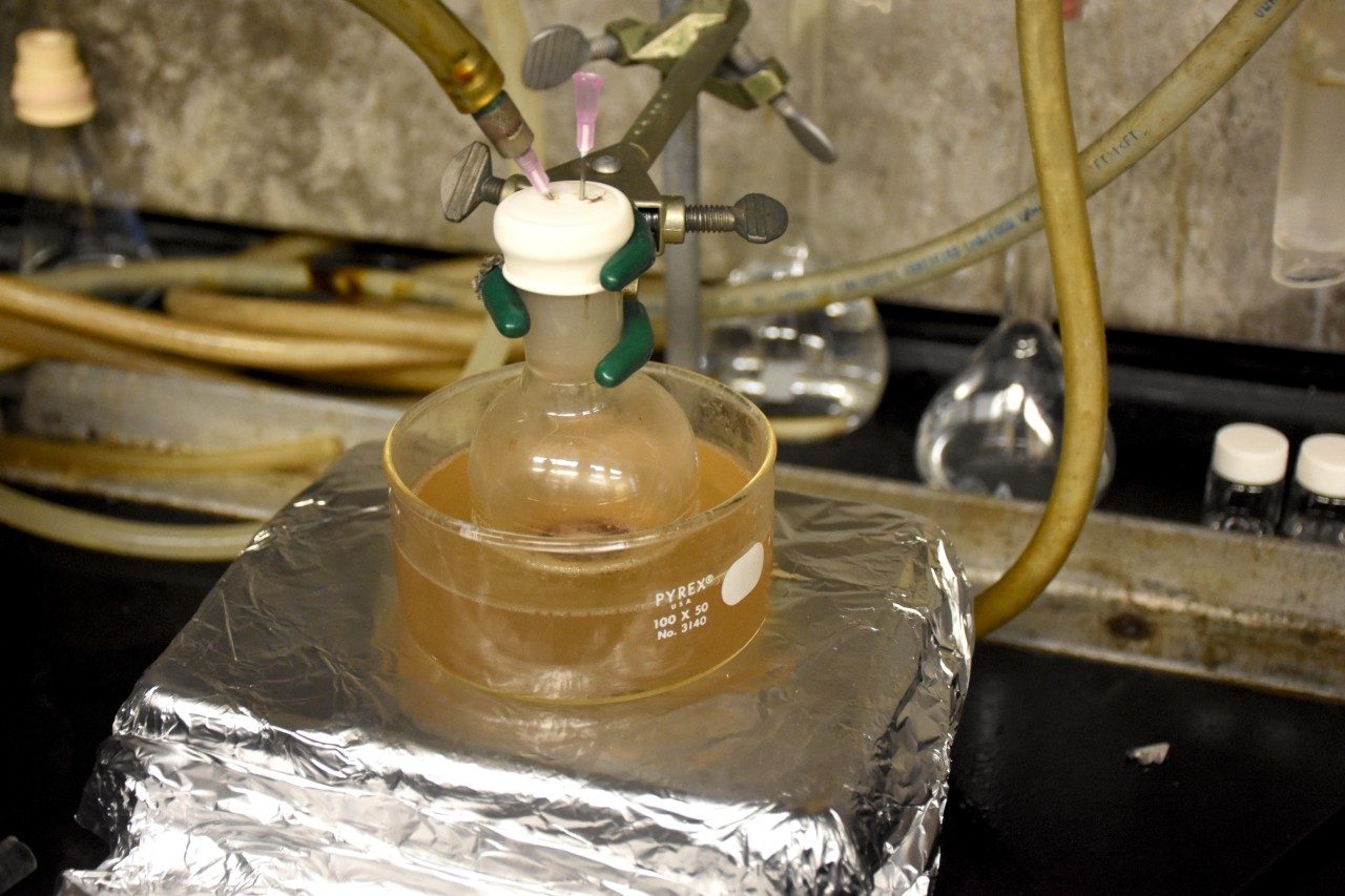 A flask filled with waxes generated from waste polyethylene and polypropylene is heated in an oil bath