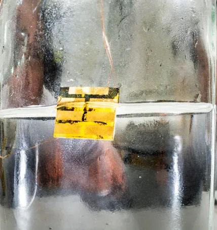 A beaker filled with water where a small solar cell is dissolved