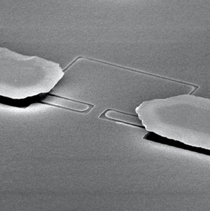  A scanning electron microscope image of a microchannel device that squeezes electron crystals on the surface of liquid helium through a narrow bottleneck