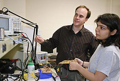 Assoc. Prof. Joel Therrien works with a student in the lab