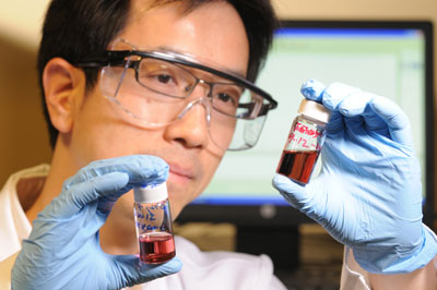 Georgia Tech professor Zhiqun Lin examines a gold nanoparticle toluene solution