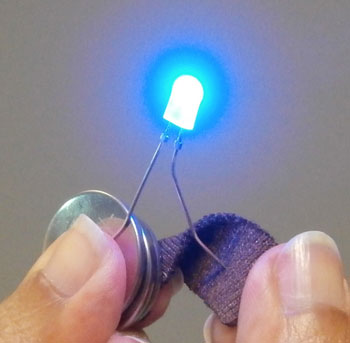 Smart fabric connected to a power source
conducting electrical charge through a LED