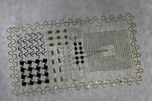 diagnostic skin containing transistors, an antenna, power coils, and temperature sensors