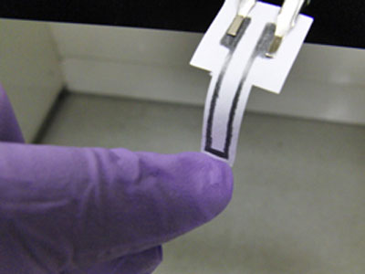 strain gauge made of pencil and paper is deformed to compress the graphene network