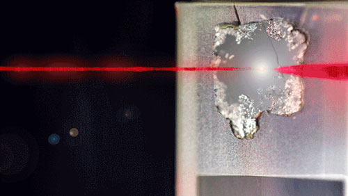 Scientists apply a pulse laser to a sample to excite the material
