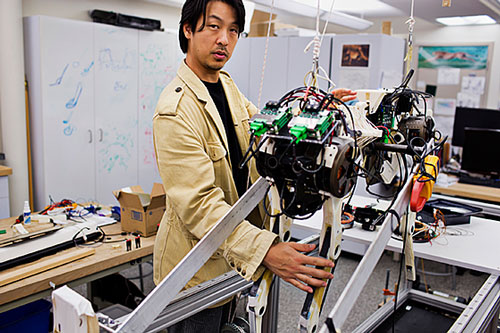 Assistant Professor Sangbae Kim works on the 70-pound 'cheetah' robot designed at MIT