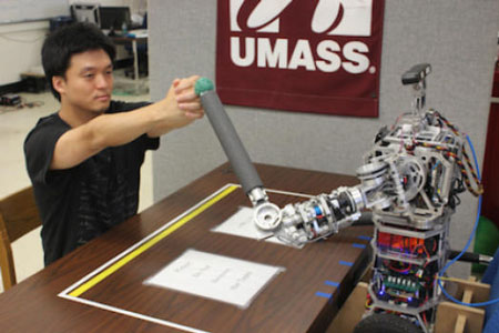 Computer science doctoral student Hee-tae Jung practicing therapeutic arm movement with a uBot5 personal robot