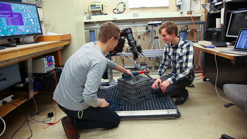 Undergraduates students Derek Martin, left, and Ryan Cox work on instrumentation with the BluHaptics team