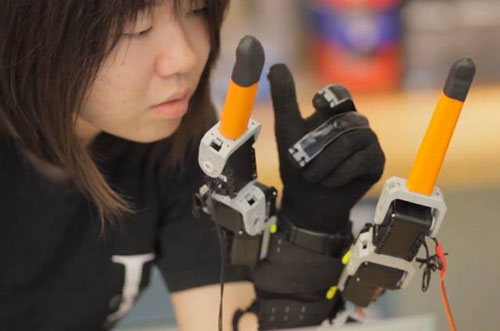 Faye Wu, a graduate student in mechanical engineering, demonstrates the 'supernumerary robotic fingers' device