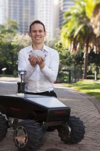 Dr Michael Milford with an all-terrain robots