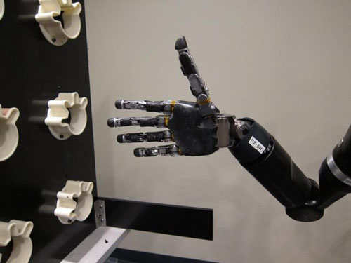 Using mind control, a woman with quadriplegia moves robot arm and hand in