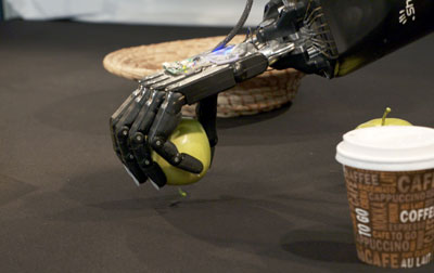 robot hand gripping apple