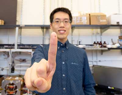 Tianqi Xu holds up a microrobot