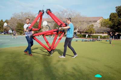 Graduate students Zachary Hammond (on left) and Nathan Usevitch pick up and move an isoperimetric robot