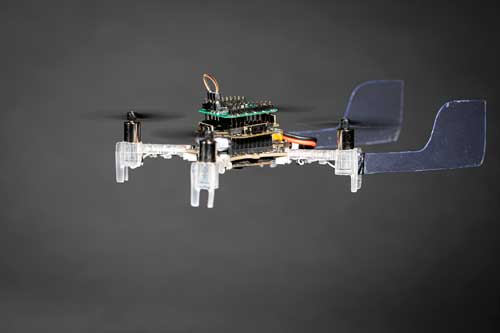 A drone hovering in midair. It has two plastic fins on its back
