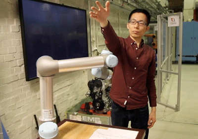 KTH researcher Hongyi Liu tests a robot arm by placing his hand in its path