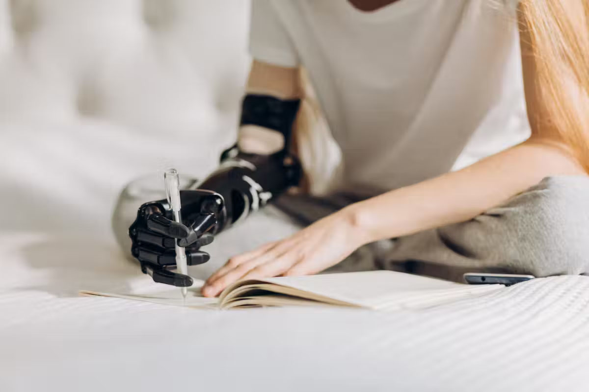 A person writing with a bionic arm