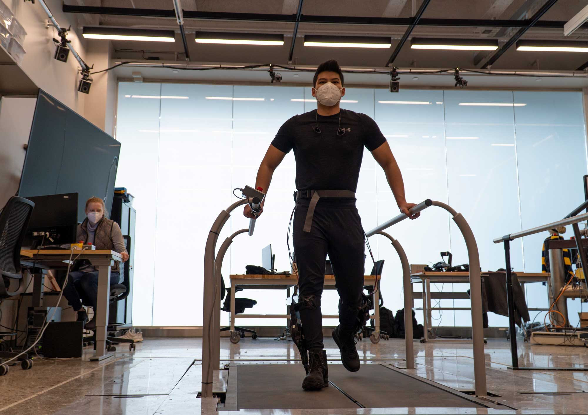 Leo Medrano tests out an ankle exoskeleton on a two-track treadmill
