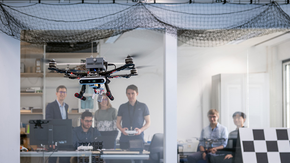 Prof. Stefan Leutenegger (left) and his team of researchers test a drone in the lab