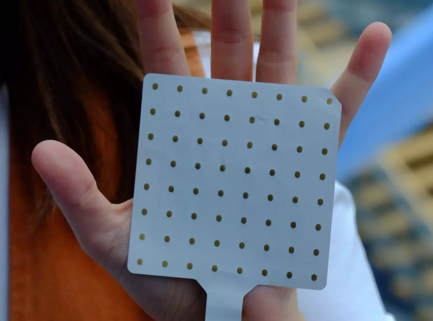 A hand prosthesis grips wan orange