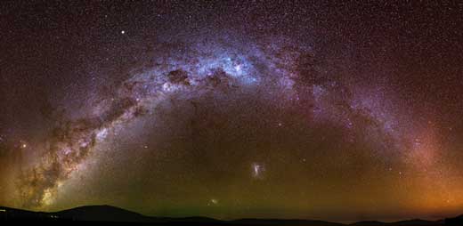 The Magellanic Clouds can be seen just above the horizon and below the arc of the Milky Way