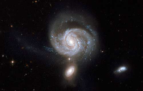 NGC 7674, seen just above the center, is a luminous spiral galaxy with a powerful active nucleus