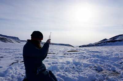 scientist sampling permafrost terrain near the McGill Arctic research station