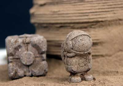 a cube and an astronaut figure made from regolith composite