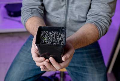 man holding pot with plant soil