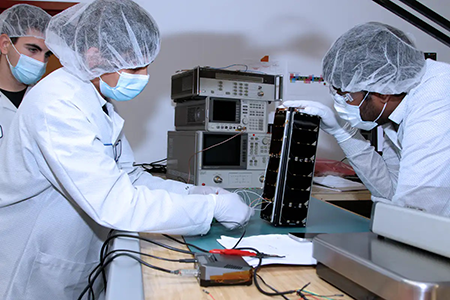 students working on a tiny satellite