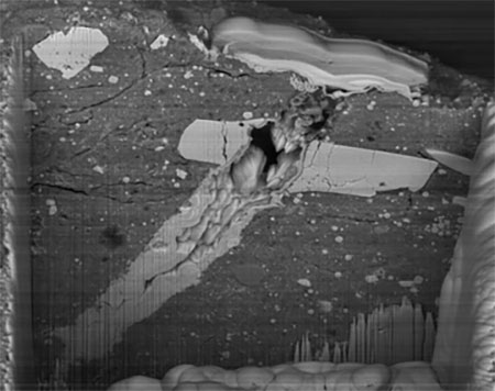 This scanning electron microscope image shows a micrometeorite impact crater in a particle of asteroid Bennu material
