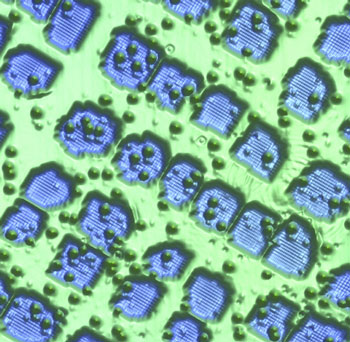 canning tunneling microscope topograph of nitride patches (blue) on a copper substrate (green) that serve as nano-workbenches for the assembly of atomic-scale prototype structures from magnetic atoms (green bumps)
